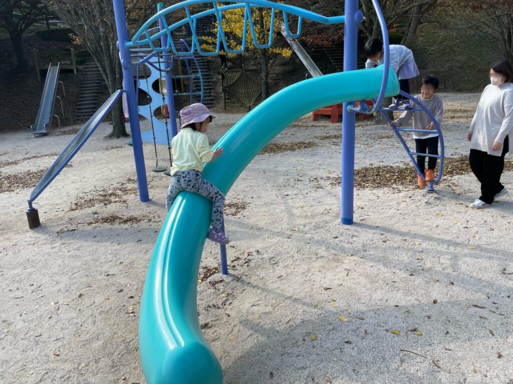 Children and parents playing with playground equipment at Mount Ohirayama Summit Park