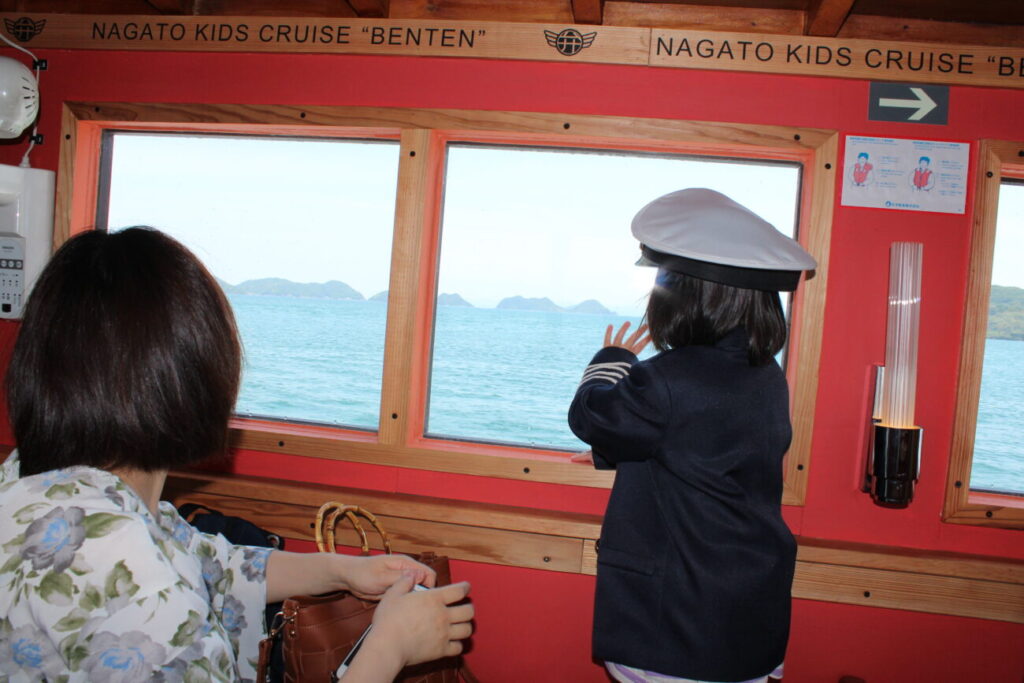 長門おもちゃ美術館のキッズクルーズ船の外を見る子供