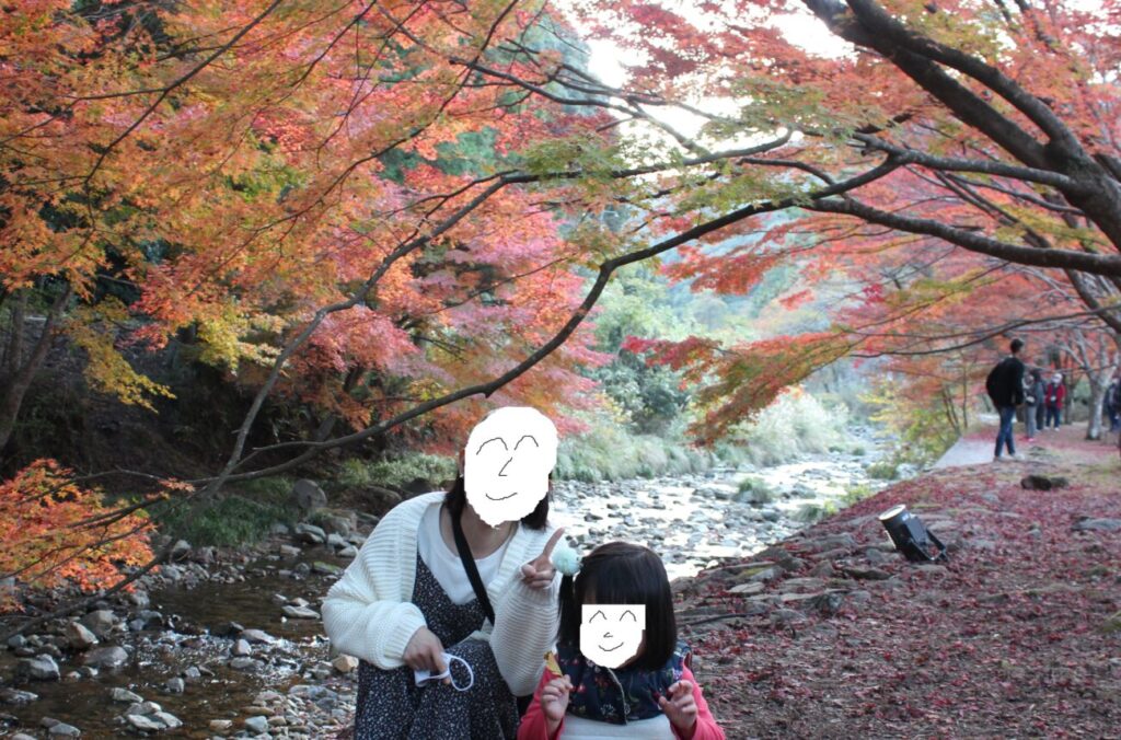 大寧寺の川の隣の紅葉と親子